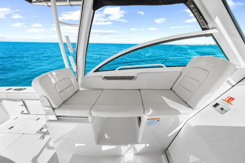 Slide: The Image of The 2027 Boston Whaler 285 Conquest features a sleek white seating area overlooking the blue ocean. - 31