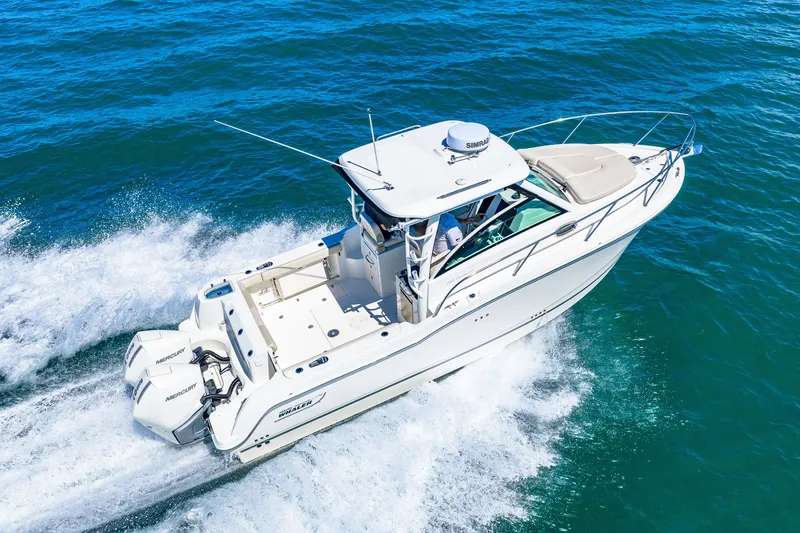 Slide: The Image of A 2027 Boston Whaler 285 Conquest speeds across blue water. It features twin outboard engines. - 10