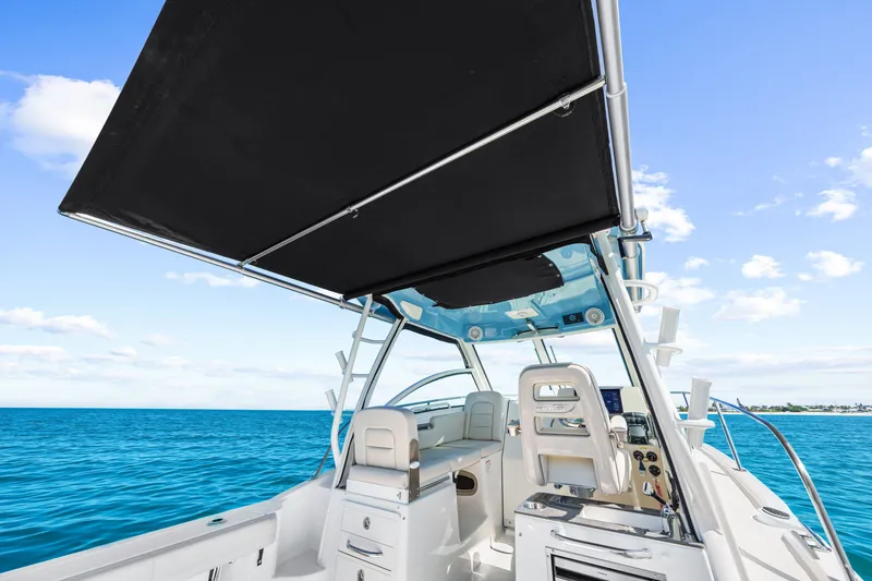 Slide: The Image of The image shows the cockpit of a Boston Whaler 285 Conquest with a black sunshade and blue sky. - 34