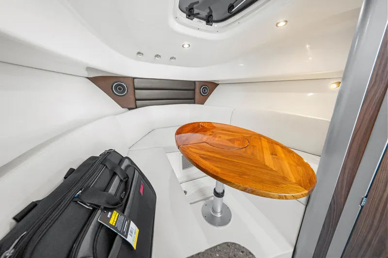 Slide: The Image of The interior of a 2027 Boston Whaler 285 Conquest features an elegant seating area with a wooden table. - 44