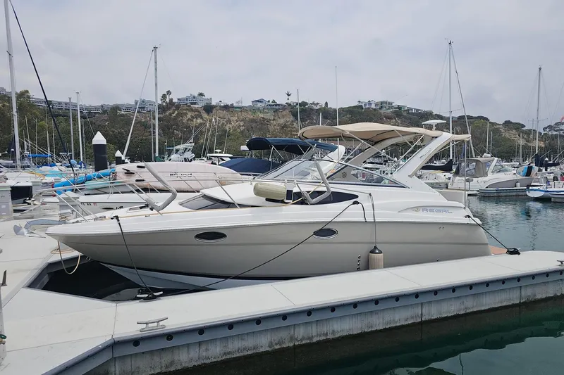 The Image of 2009 Regal 2860 Window Express boat docked in a marina, surrounded by other vessels. - 1