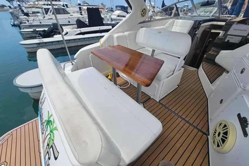 Slide: The Image of 2009 Regal 2860 Window Express boat interior with white seating and wooden table. - 15
