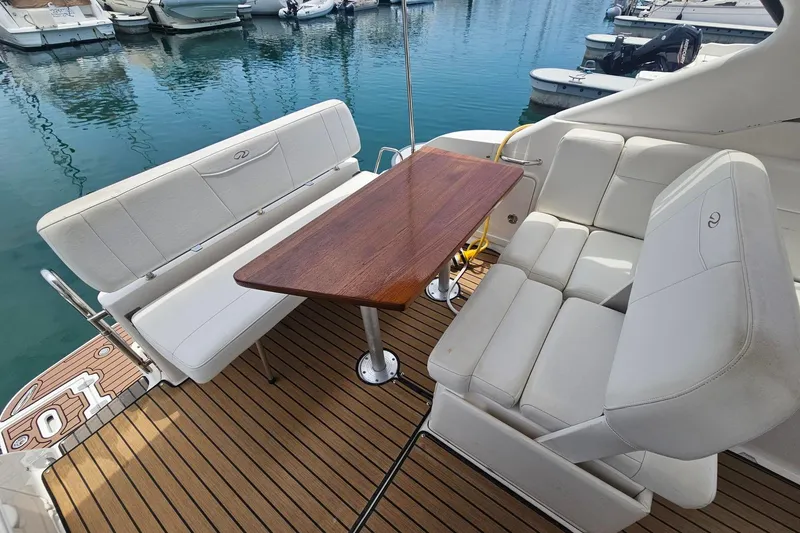Slide: The Image of 2009 Regal 2860 Window Express boat interior with white seating and wooden table. - 17