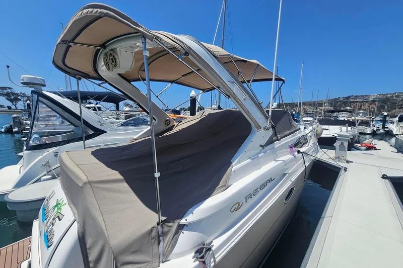 Slide: The Image of 2009 Regal 2860 Window Express boat docked at marina under clear blue sky. - 2