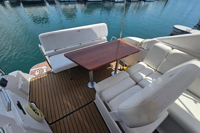Slide: The Image of 2009 Regal 2860 Window Express boat interior with white seating and wooden table. - 22