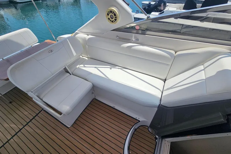 Slide: The Image of 2009 Regal 2860 Window Express boat interior with white seating and wooden deck. - 23
