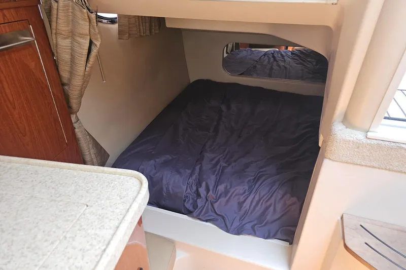 Slide: The Image of 2009 Regal 2860 Window Express cabin interior with cozy bed and wooden cabinetry. - 29
