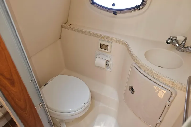 Slide: The Image of Compact bathroom in 2009 Regal 2860 Window Express boat with toilet, sink, and porthole. - 33