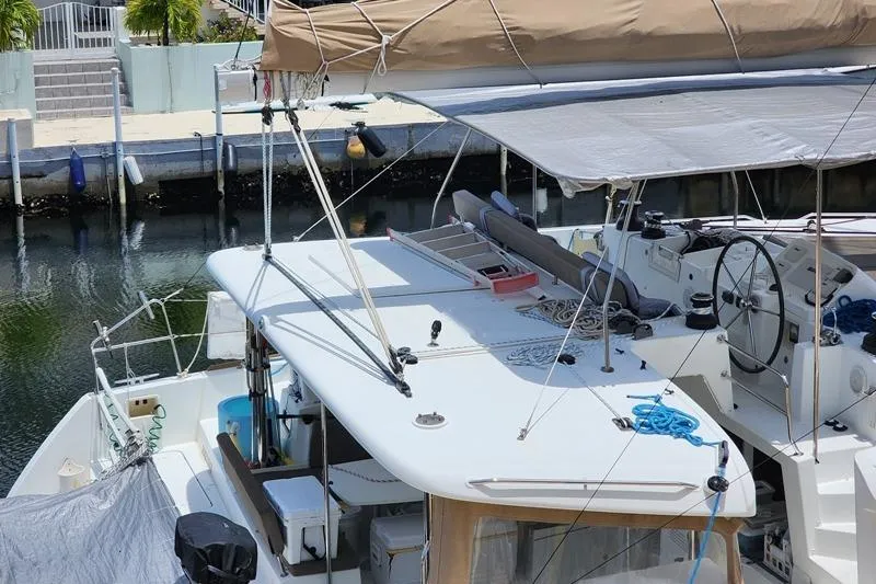 The Image of 2016 Lagoon 450 F catamaran docked, featuring spacious deck and helm station. - 1