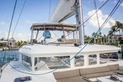 Slide: The Image of 2016 Lagoon 450 F catamaran with spacious deck and modern design in a marina setting. - 14