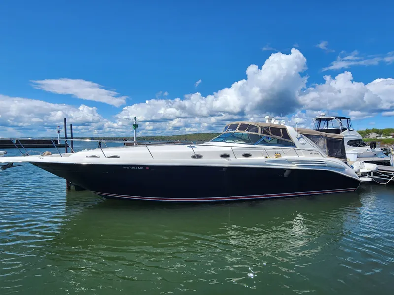 Slide: The Image of 1997 Sea Ray 450 Sundancer yacht docked under sunny skies. - 1
