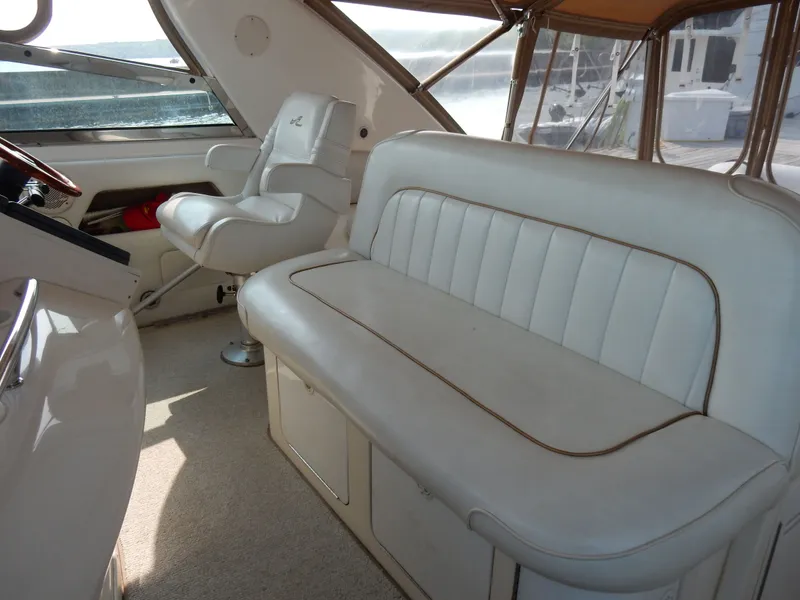 Slide: The Image of Interior of a 1997 Sea Ray 450 Sundancer yacht with white leather seating. - 14