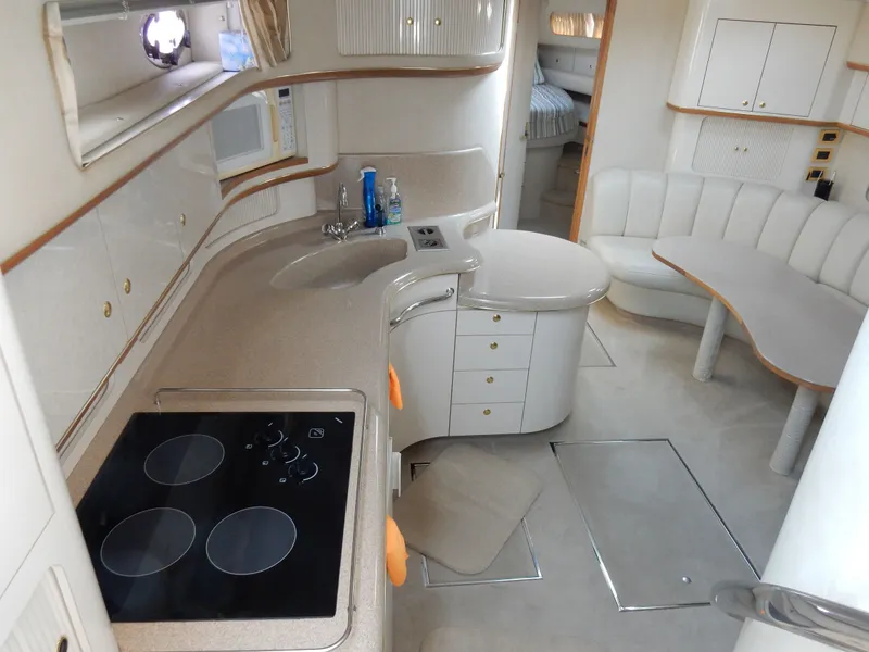 Slide: The Image of Interior of a 1997 Sea Ray 450 Sundancer yacht, featuring modern kitchen and seating area. - 15