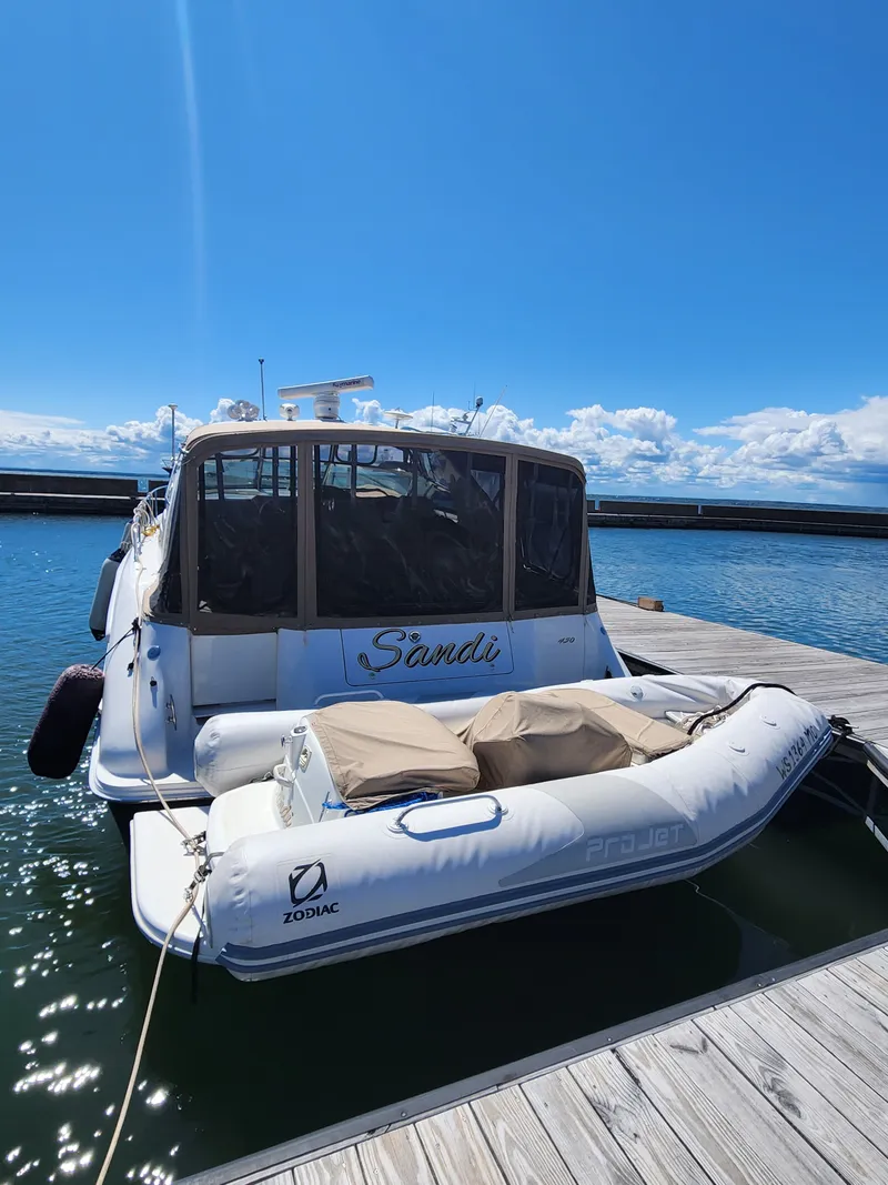 Slide: The Image of 1997 Sea Ray 450 Sundancer with Zodiac dinghy at dock. - 2