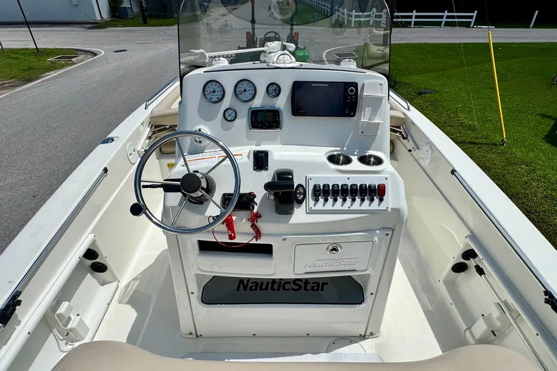 Slide: The Image of 2017 NauticStar 211 Coastal boat dashboard with steering wheel, gauges, and controls. - 10