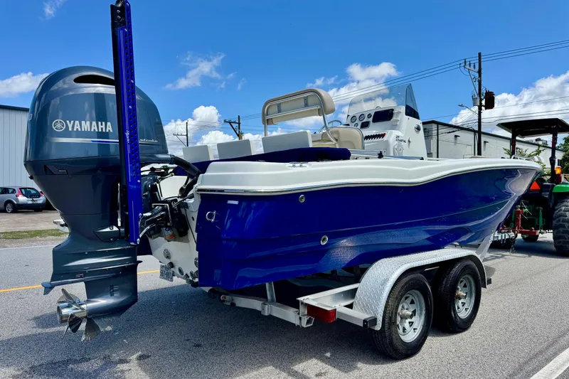 Slide: The Image of 2017 NauticStar 211 Coastal boat with Yamaha engine on a trailer, parked outdoors. - 4