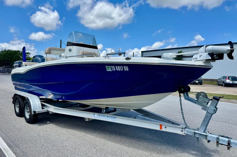 Slide: The Image of 2017 NauticStar 211 Coastal boat on trailer under blue sky. - 5