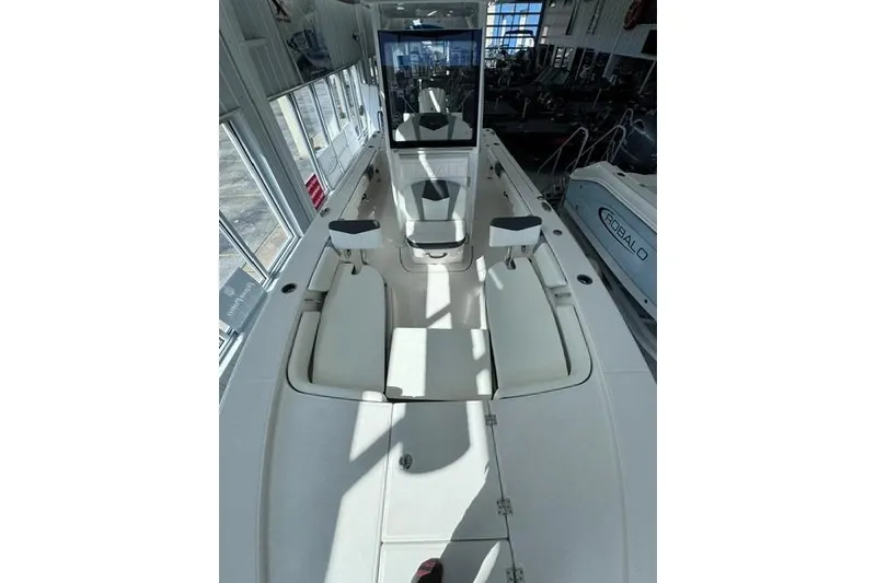 Slide: The Image of 2023 Robalo 246 Cayman boat interior with seating and console in showroom. - 7