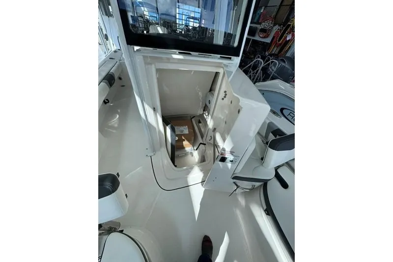 Slide: The Image of 2023 Robalo 246 Cayman boat interior storage compartment open, showcasing spacious design. - 9