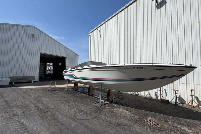 Slide: The Image of 1991 Formula 311 SR-1 boat on stands outside a large white storage building. - 11