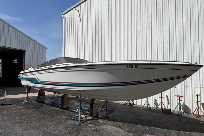 Slide: The Image of 1991 Formula 311 SR-1 boat on stands outside a large white building. - 12