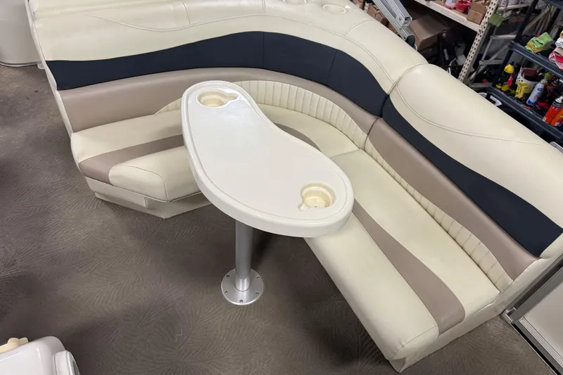 Slide: The Image of 2008 Bennington 2075GSi boat seating with integrated cup holders and table in a workshop setting. - 8