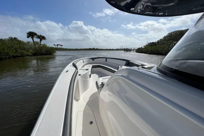 Slide: The Image of 2021 Fountain 39 NX boat cruising on a scenic river under a clear blue sky. - 36