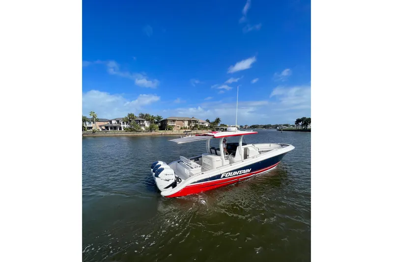 Slide: The Image of 2021 Fountain 39 NX boat cruising on a sunny day near waterfront homes. - 23