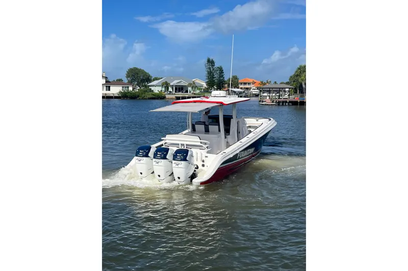 Slide: The Image of 2021 Fountain 39 NX boat cruising on a sunny day with triple outboard engines. - 22
