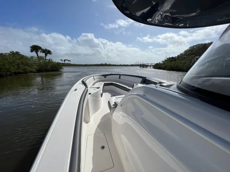 Slide: The Image of 2021 Fountain 39 NX boat cruising on a scenic river with lush greenery. - 30