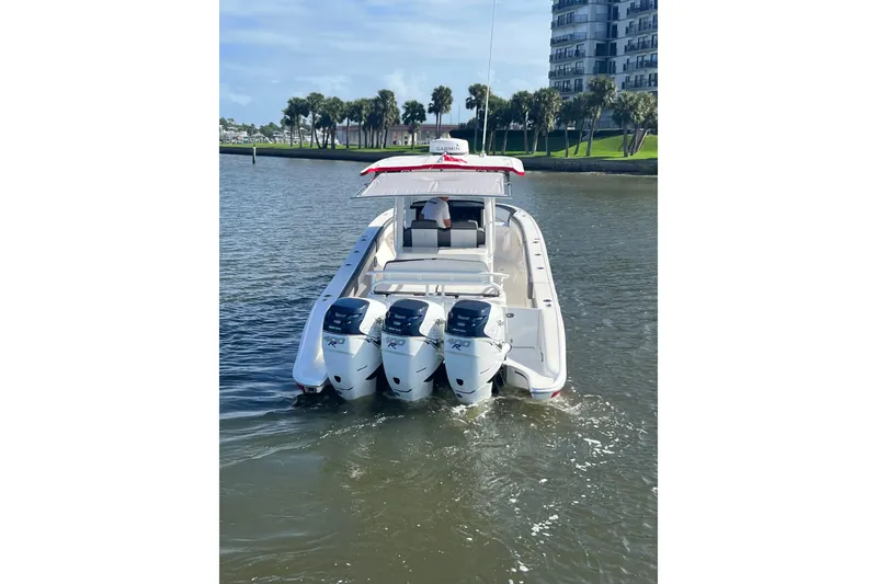 Slide: The Image of 2021 Fountain 39 NX boat with triple outboard engines on a calm waterway. - 25