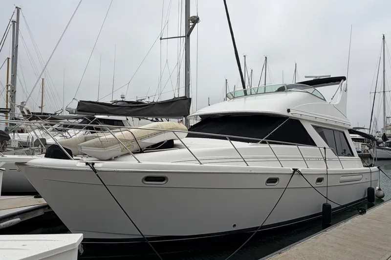 Slide: The Image of 1996 Bayliner 3988 Command Bridge Motoryacht docked at marina, overcast sky. - 1