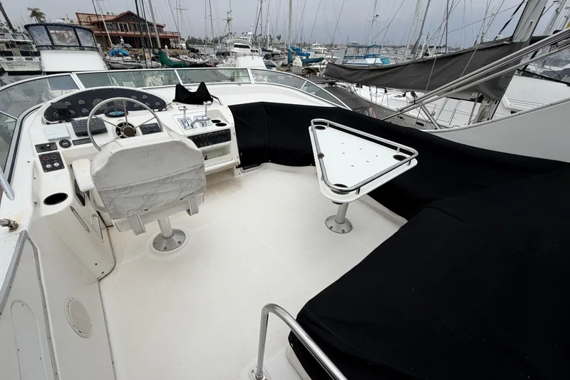 Slide: The Image of 1996 Bayliner 3988 Command Bridge Motoryacht helm with covered seating and marina view. - 13