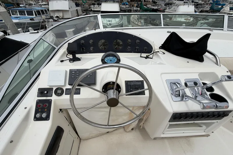 Slide: The Image of 1996 Bayliner 3988 Command Bridge Motoryacht helm with steering wheel and controls. - 15