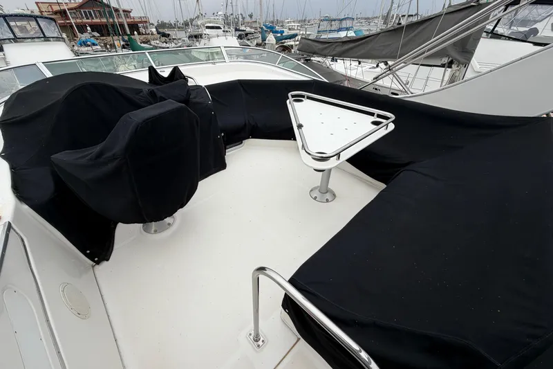 Slide: The Image of 1996 Bayliner 3988 Command Bridge Motoryacht deck with covered seating and triangular table. - 16