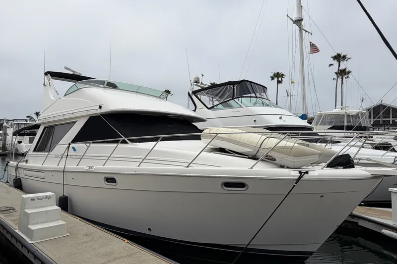 Slide: The Image of 1996 Bayliner 3988 Command Bridge Motoryacht docked at marina, overcast sky. - 2