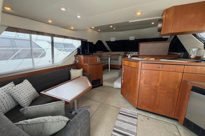 Slide: The Image of Interior of 1996 Bayliner 3988 Command Bridge Motoryacht with cozy seating and wooden cabinetry. - 24