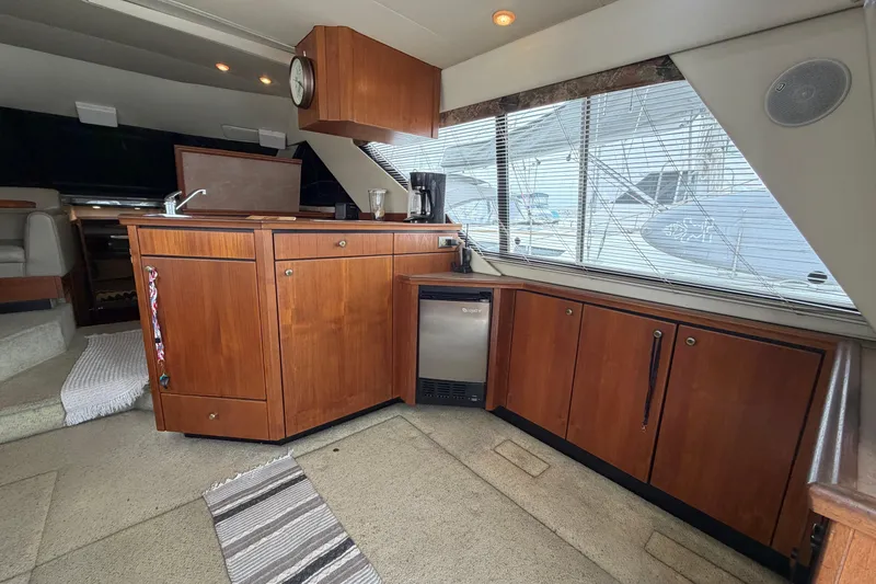 Slide: The Image of Interior of 1996 Bayliner 3988 Command Bridge Motoryacht with wooden cabinetry and compact kitchen area. - 25