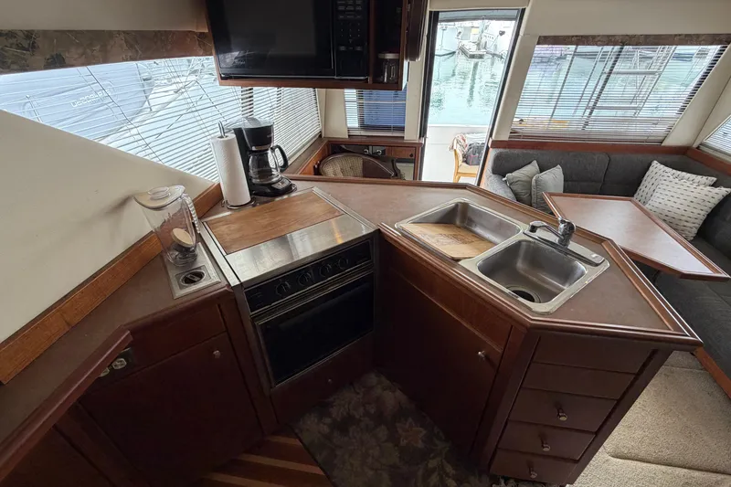 Slide: The Image of Interior of 1996 Bayliner 3988 Command Bridge Motoryacht kitchen with stove, sink, and seating area. - 31