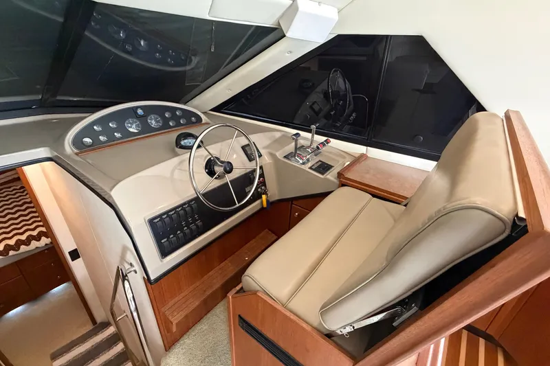 Slide: The Image of 1996 Bayliner 3988 Command Bridge Motoryacht helm with steering wheel and control panel. - 34