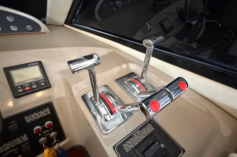 Slide: The Image of 1996 Bayliner 3988 Command Bridge Motoryacht control panel with throttle levers and navigation display. - 36