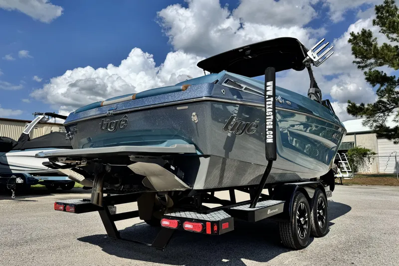 Slide: The Image of 2021 Tigé 23ZX boat on trailer under a partly cloudy sky. - 4
