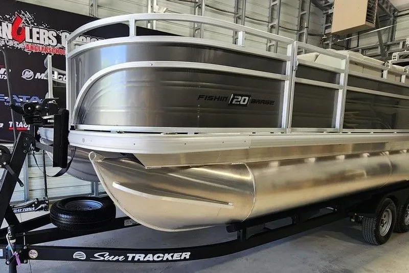 The Image of 2026 Sun Tracker Fishin' Barge 20 DLX pontoon boat in a showroom setting. - 1