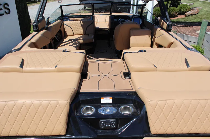 Slide: The Image of 2022 Tigé 22RZX boat interior with tan quilted seating and modern dashboard. - 10