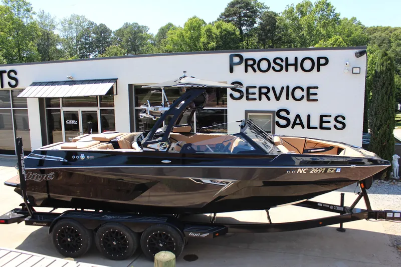 Slide: The Image of 2022 Tigé 22RZX boat on trailer outside service and sales shop. - 2