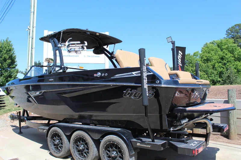 Slide: The Image of 2022 Tigé 22RZX boat on trailer, sleek black design, outdoor display. - 6