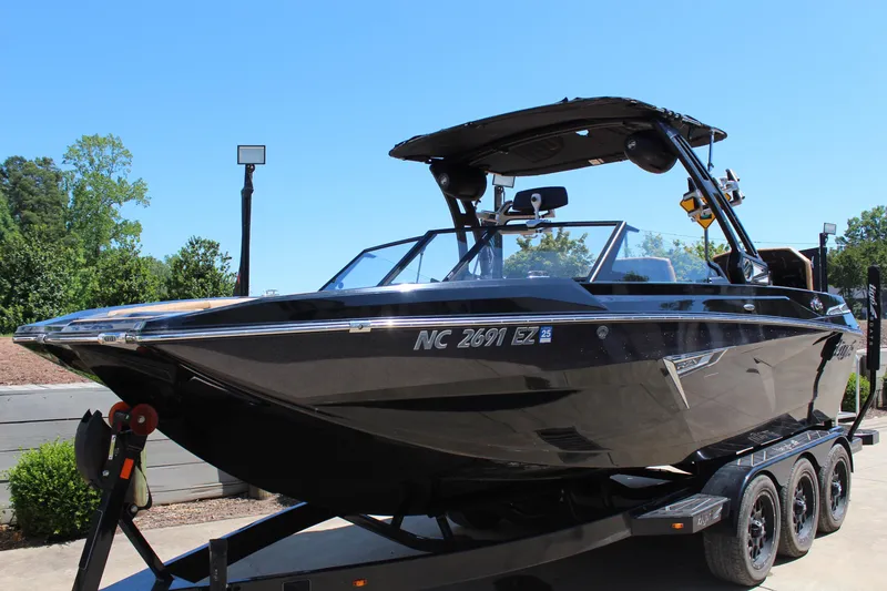 Slide: The Image of 2022 Tigé 22RZX boat on trailer, sleek black design, parked outdoors. - 7