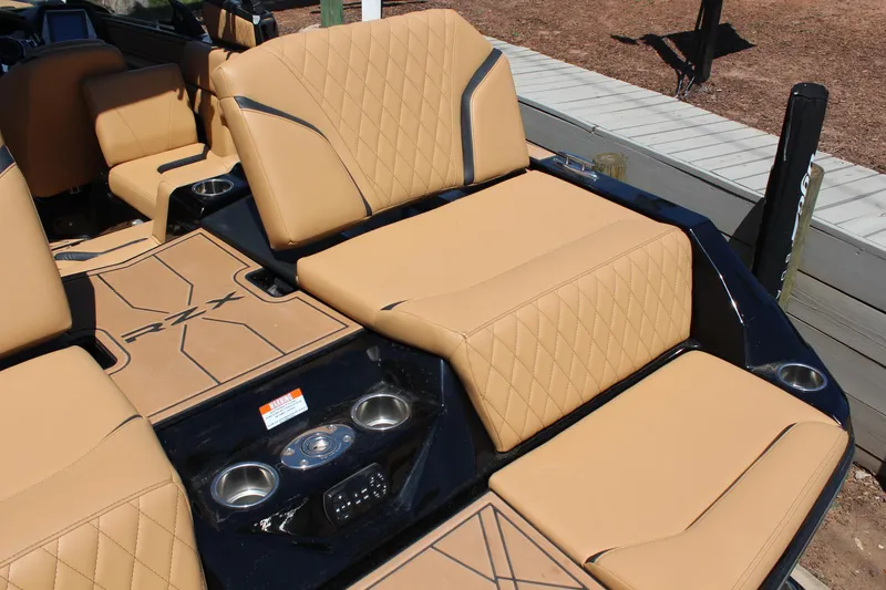 Slide: The Image of 2022 Tigé 22RZX boat interior with tan diamond-stitched seats and cup holders. - 8