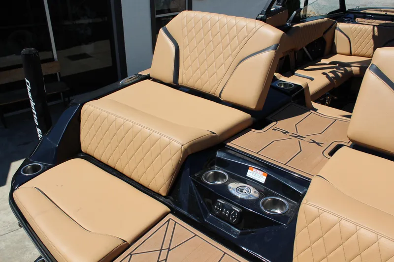 Slide: The Image of 2022 Tigé 22RZX boat interior with tan quilted seats and cup holders. - 9