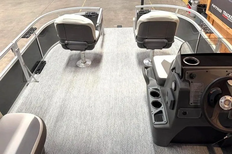 Slide: The Image of 2026 Sun Tracker Bass Buggy 16 XL Select pontoon boat interior with seating and steering console. - 2